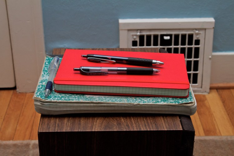 The new notebook and pens sitting on the old